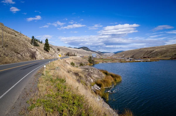 Autobahn am Rande eines malerischen Bergsees — Stockfoto