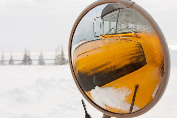 Yan aynasından yansıyan sarı okul otobüsü