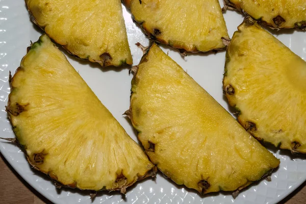 Seis pedaços de abacaxi, deitados juntos em um prato branco — Fotografia de Stock