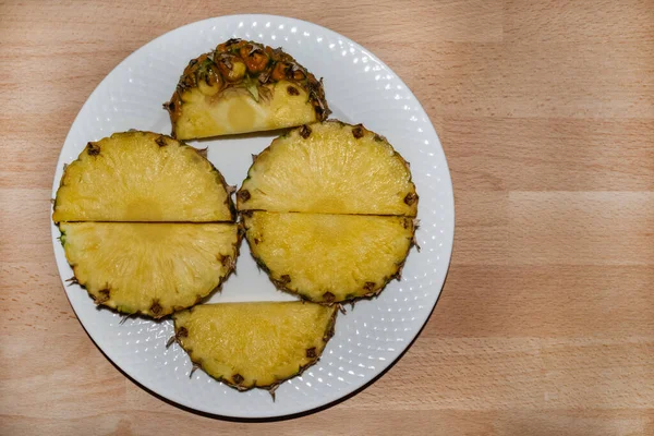 Ananas parçaları, beyaz tabakta ikiye bölünmüş. — Stok fotoğraf