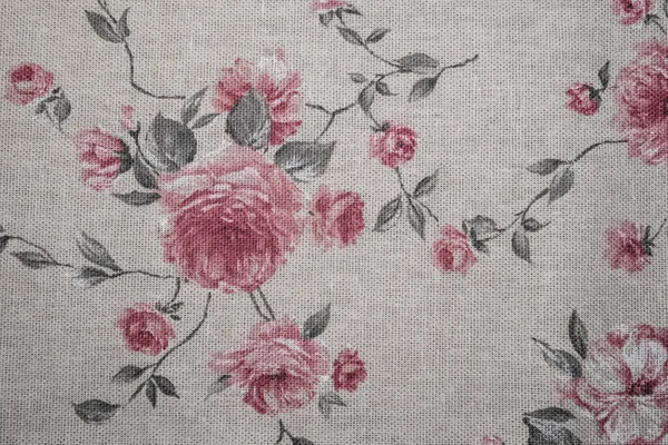Detailní záběr vyšívaného bavlněného ubrousku s pastelově růžovými růžemi a tmavozelenými listy kresby — Stock fotografie