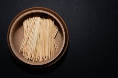 Yuvarlak ahşap kasede fotokopi alanı olan bir kürdan yığını.