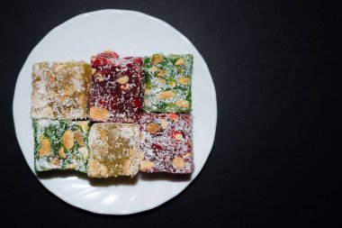 Küçük beyaz tabakta yer fıstığı ve hindistan cevizi parçalı altı parça Türk Lokumu