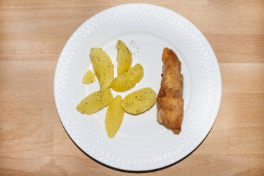 Kızarmış tavuk nugget ve beyaz tabakta dereotlu patates.