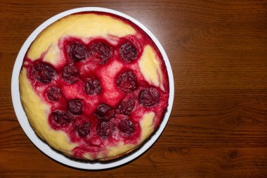 Beyaz tepside kırmızı erikli ev yapımı yuvarlak turta.