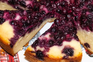 Siyah üzümlü taze pişmiş kek, tabakta üçgen parçalara bölünmüş.