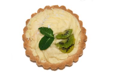 Krem peynirli, nane yapraklı, kivi meyveli ve beyaz arka planda hindistan cevizli taze pişmiş tart.