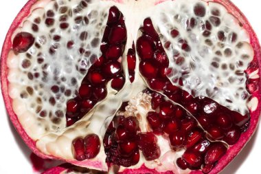 Half a pomegranate with fresh juicy red seeds. Isolated