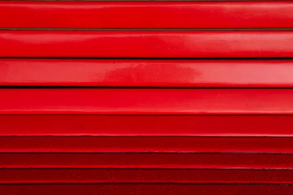 Close up of horizontal gradient red wood bench planks with rain drops — Stock Photo, Image