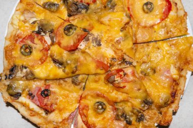 Peynirli, domatesli, mantarlı ve sosisli büyük pizza dilimleri kes.