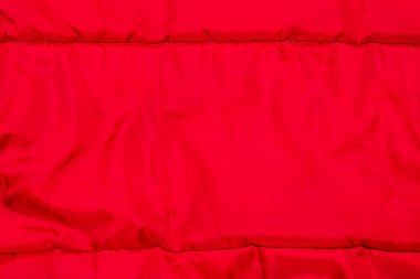 Dikişleri olan katlanmış kırmızı naylon kumaş.