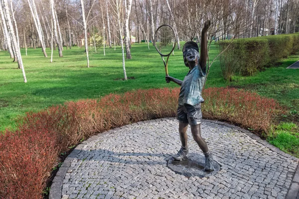 Kharkiv, Ukrayna - 17 Nisan 2021. Sağ elinde tenis raketi olan, topu servis eden bir çocuk heykeli. Central Park