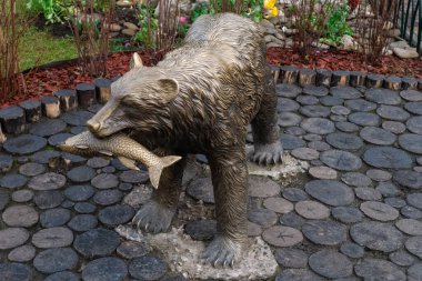 Kharkiv, Ukrayna - 17 Nisan 2021. Central Park 'ta ağzında balık olan bronz ayı heykeli.