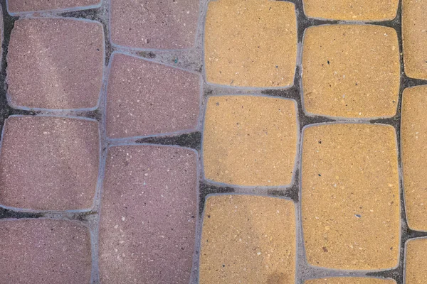 Закрыть равномерно смешанной желтой и красной уличной плиткой — стоковое фото