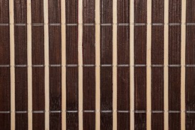 Dikey çizgili ışığın ve koyu kahverengi bambu yastığın makro görüntüsü