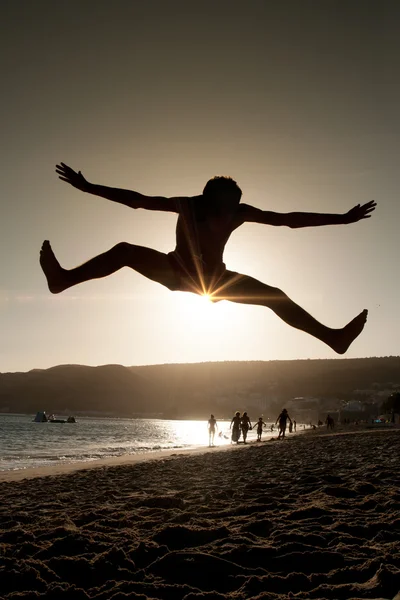 男孩跳上海滩 — 图库照片
