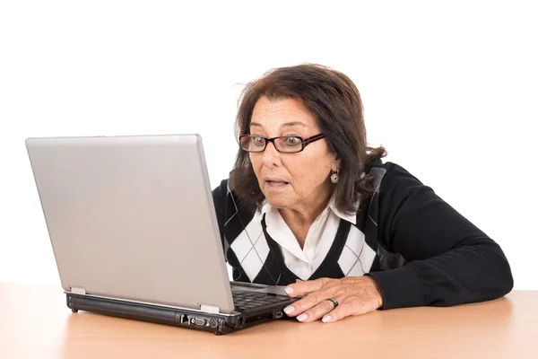 Förvånad över äldre kvinna med laptop — Stockfoto