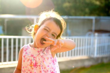 Tatlı genç kız gün batımında dışarıda surat yapıyor.