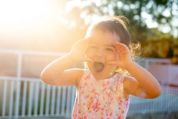 可爱的小女孩日落时在户外做鬼脸 — 图库照片