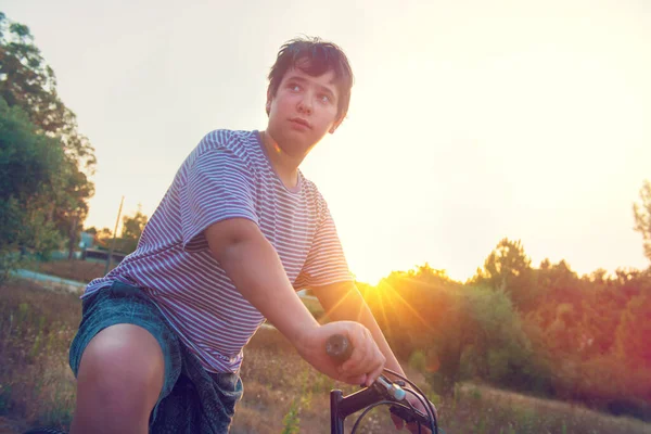 日落时 快乐的男孩在户外骑自行车 — 图库照片