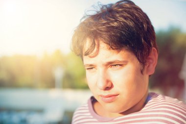 Yakışıklı çocuk gün batımında dışarıda poz veriyor.