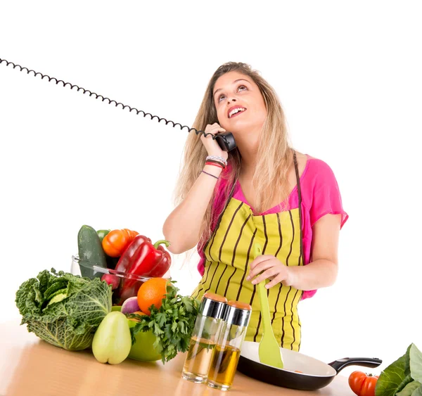 Femme cuisine et parle au téléphone — Photo