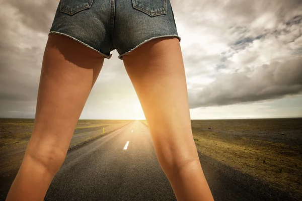 Las piernas de la mujer en el camino — Foto de Stock