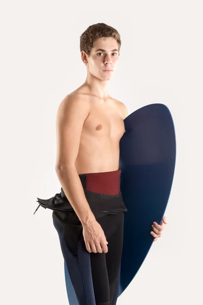 Nastolatek z deską surfingową na biały — Zdjęcie stockowe
