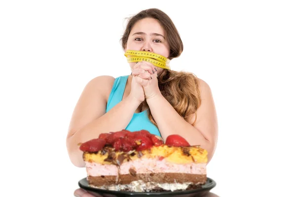 Ragazza grande guardando una torta — Foto Stock