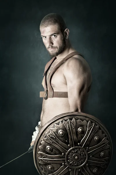 Gladiator posiert mit Schild und Schwert — Stockfoto