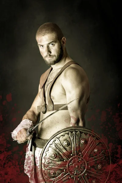 Gladiator posiert mit Schild und Schwert — Stockfoto