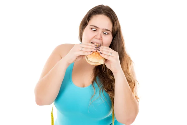 太った女の子がハンバーガーを食べて — ストック写真