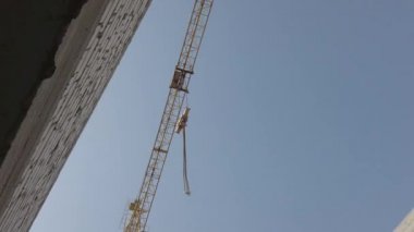 İnşaatta kullanılan paslı kanca, mavi gökyüzü inşaatında ağır ekipmanları kaldırmak için kullanılıyor. Yakın plan..