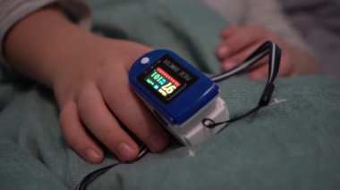 Avrupa, Kiev, Ukrayna - Kasım 2020: Çocukların elleri oksijen seviyelerini nabız oksimetresiyle ölçer. Covid-19 koronavirüs salgınında oksijeni ölçmek için bir atım oksimetresi..