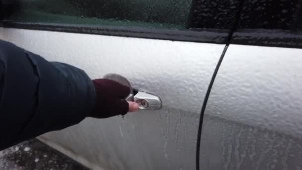 Europa, Ukraina, Kiev - december 2020: Öppnandet av den isiga bilen. Bilen öppnas inte på grund av is. Uppvärmning av bilen under isiga förhållanden. Bildörren är frusen och går inte att öppna. — Stockvideo