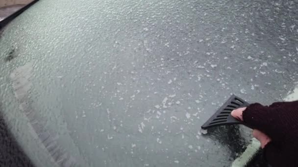Европа, Украина, Киев - декабрь 2020: подогрев автомобиля в ледяных условиях. Уборка машины со льдом. Рука моет годы на стекле машины. — стоковое видео
