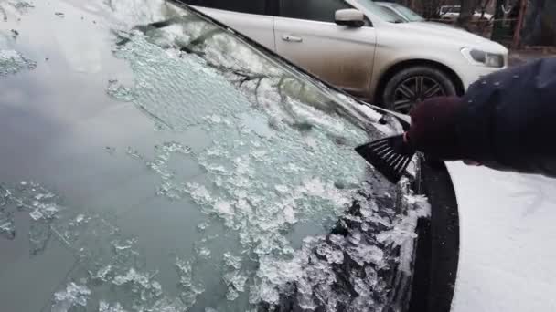 Европа, Украина, Киев - декабрь 2020: подогрев автомобиля в ледяных условиях. Уборка машины со льдом. Рука моет годы на стекле машины. — стоковое видео