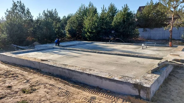 Özel bir kulübenin inşaatı. Gelecekteki evin temelleri çam ağaçları arasında..