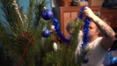 Avrupa, Ukrayna, Kiev - Aralık 2020: Noel ağacı süslemesi. Çocuklu bir anne yeni yıl ağacını süslüyor. Apartmandaki canlı bir çam ağacında güzel yeni yıl oyuncakları.