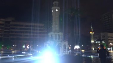 İzmir, Türkiye - Ocak 2021: Eski Saat yakınlarındaki ışık gösterisi. Gece gökyüzünde ışık huzmeleri.