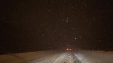 Avrupa, Kiev, Ukrayna - Şubat 2021: Bir araba kar fırtınası sırasında karla kaplı bir pistte ilerliyor. Arabadan bak. Gece yolu.