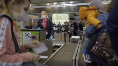 Avrupa, Ukrayna, Kiev - Nisan 2021: Covid-19 Coronavirus salgını sırasında Boryspil Uluslararası Havalimanı 'ndaki check-in gişesindeki yolcular. Giriş sırasında maske takan yolcular. 