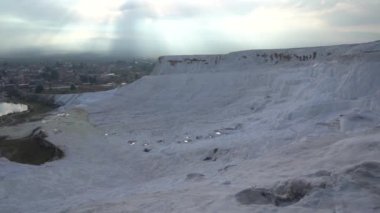 Pamukkale, Türkiye - Ocak 2021: Turistler Pamukkale 'deki termal yaylar boyunca yürüyorlar. Gün batımı
