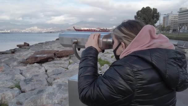Izmir, Turecko - leden 2021: Dívka se dívá dalekohledem na nábřeží. Turistický dalekohled. — Stock video