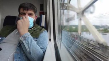 Kiev-Harkiv, Avrupa, Ukrayna - Haziran 2021: Maskeli bir yolcu yüksek hızlı bir trenle seyahat ediyor. Covid-19 Coronavirus salgını sırasında yüksek hızlı bir trenin penceresinden görüntüle.