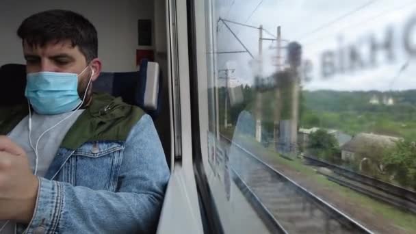 Kijów-Charków, Europa, Ukraina - czerwiec 2021: Zamaskowany pasażer podróżuje pociągiem dużych prędkości. Widok z okna pociągu dużych prędkości podczas pandemii Covid-19. — Wideo stockowe