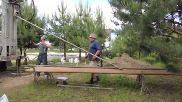 Europa, región de Kiev, Ucrania - Junio 2021: Un ingeniero está perforando un pozo de agua. Trabajador de plataforma de perforación durante el trabajo. El proceso de perforación de un pozo para el agua. Plataforma de perforación. — Vídeo de stock