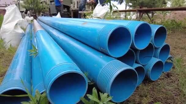 Europa, região de Kiev, Ucrânia - junho de 2021: tubos de alimentação close-up. Um engenheiro faz um poço para a água. Trabalhador do equipamento de perfuração durante o trabalho. O processo de perfuração de um poço para água potável. Água de perfuração w — Vídeo de Stock