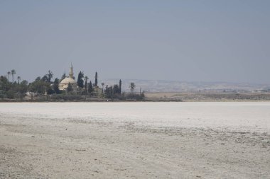 Larnaca, Kıbrıs, Eylül 2021: Hala Sultan Tekke Camii bir tuz gölünün arka planında. Kurumuş tuz gölü. Dünya yüzeyindeki doğal tuz..