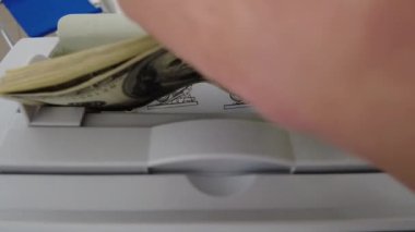 Banknotlar için sayma makinesi. Hesap makinesindeki dolarlar. Dolar banknotlarının yeniden hesaplanması. Amerikan doları banknotlar için bir makine tarafından sayılır..